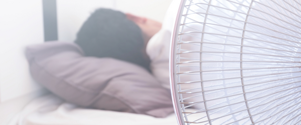 Man sleeping next to fan