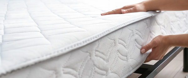 Person placing mattress on a metal bed frame