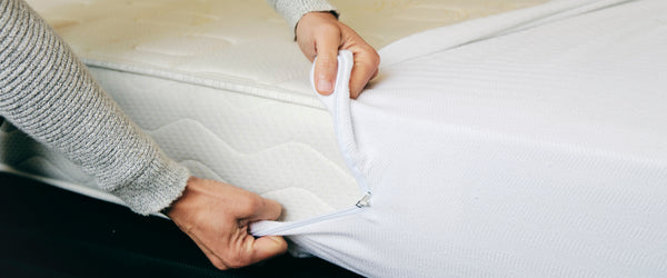 Man putting mattress protector on a mattress