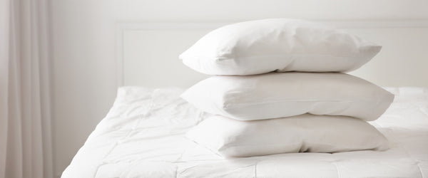 Three pillows stacked on bed