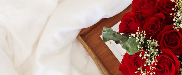 Luxury bed sheets with tray and red roses