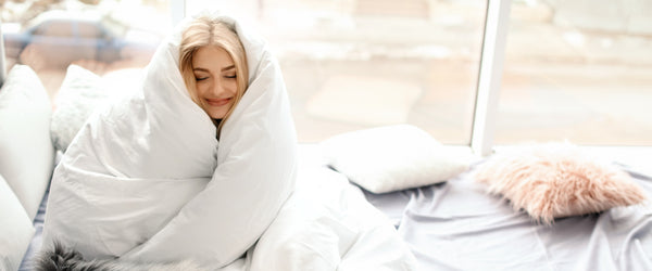 Woman wrapped in fluffy white comforter